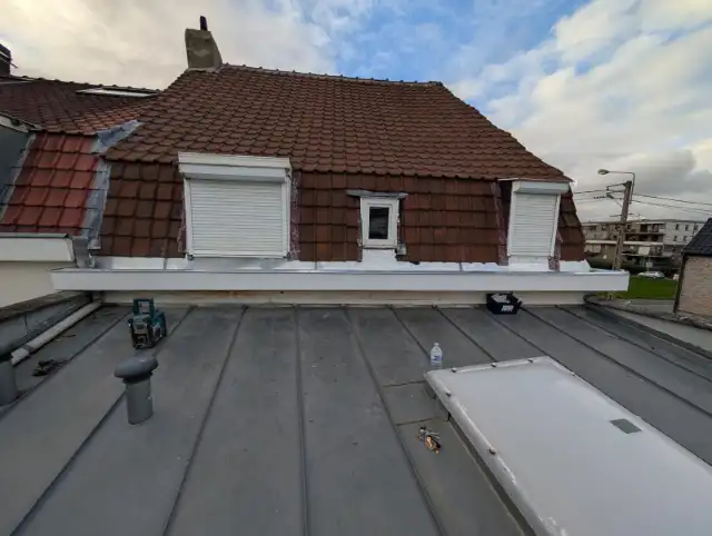 Toit plat en zinc à joint debout et corniche rénovée, sous une mansarde en tuiles